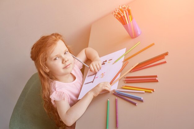 Zeichnung eines kleinen Mädchens Geschlossene Locking-Übung Hausgemachte Routine Schulunterricht Schreiben Sie Bleistift auf ein Blatt Papier Kindergarten lernen Elementare Vorschule Studentin Denken oder Träumen