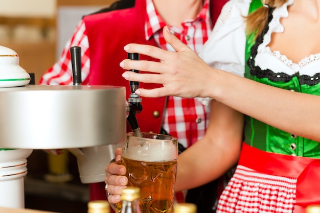 Zeichnungsbier der jungen Frau im Restaurant oder in der Kneipe