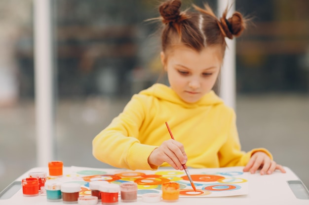 Zeichnungskunstbild des kleinen Mädchens Malen mit Pinsel und Farben