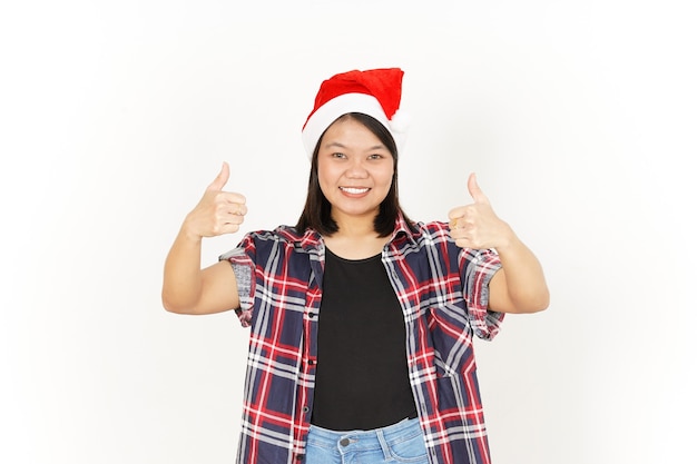 Zeigen Daumen hoch der schönen asiatischen Frau mit rotem kariertem Hemd und Weihnachtsmütze isoliert auf weiß