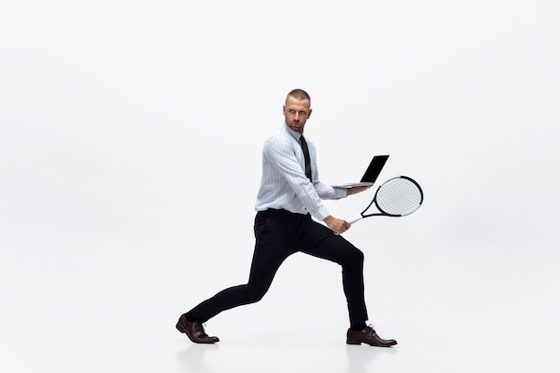 Zeit für Bewegung Mann in Bürokleidung spielt Tennis isoliert auf weißem Studiohintergrund