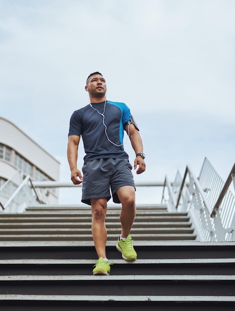 Zeit für ein paar ernsthafte Übungen Low Angle Shot eines jungen Mannes, der in der Stadt joggen geht