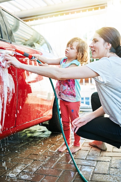 Zeit miteinander verbringen Aufnahme einer Mutter und ihrer Tochter, die gemeinsam ein Auto waschen