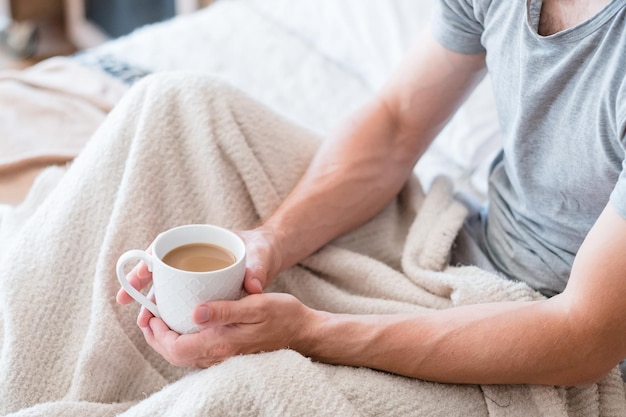 Zeit zum Aufwachen Kaffee im Bett Mann Lebensstil Hände um Tasse Latte Ruhig mit Lieblingsgetränk