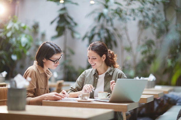 Zeitgenössische junge Frauen, die im Cafe arbeiten