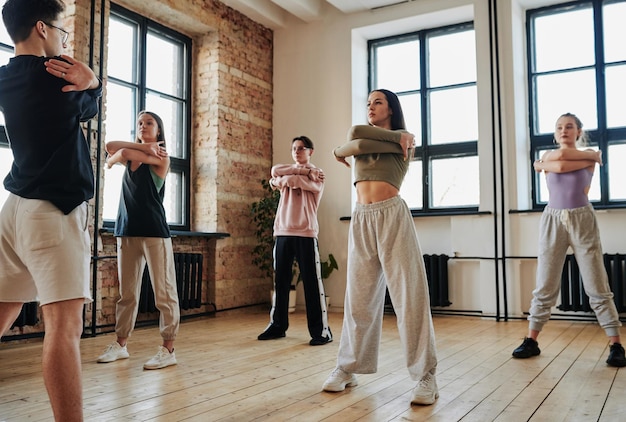 Zeitgenössische Teenager stehen während des Trainings vor Vogue-Tanzlehrern