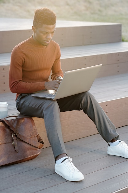 Zeitgenössischer Geschäftsmann oder Student mit Laptop im Freien