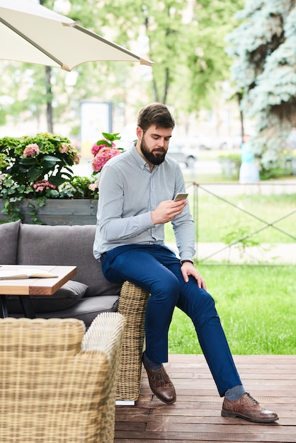 Zeitgenössischer Mann mit Smartphone im Freien