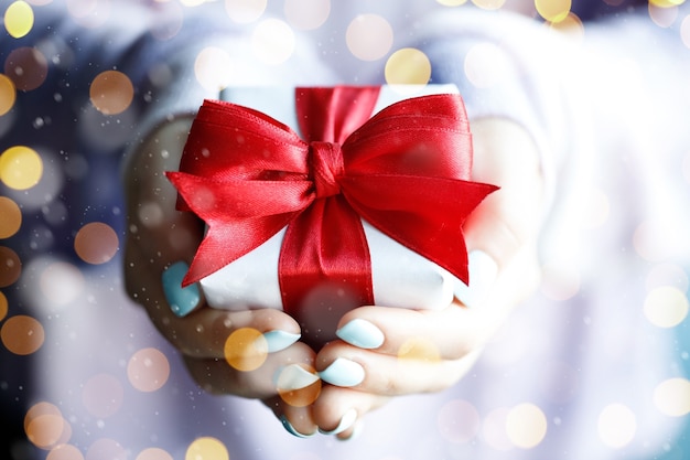 Foto zeitgeschenke - geschenkbox in der hand mädchen mit goldenen lichtern