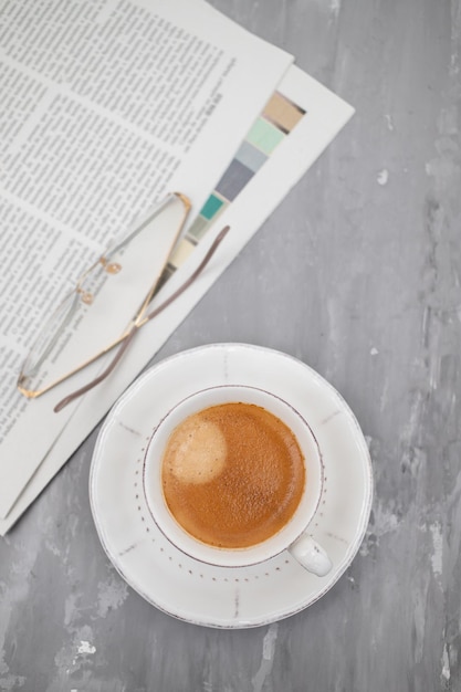 Zeitungen und Kaffeetasse mit Lesebrille