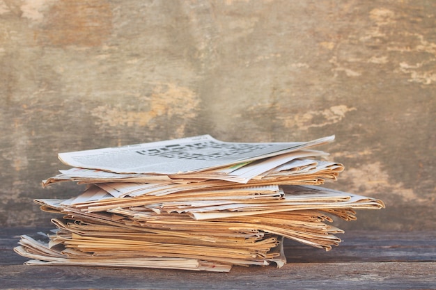 Zeitungen und Zeitschriften auf altem Holzhintergrund. Getöntes Bild.