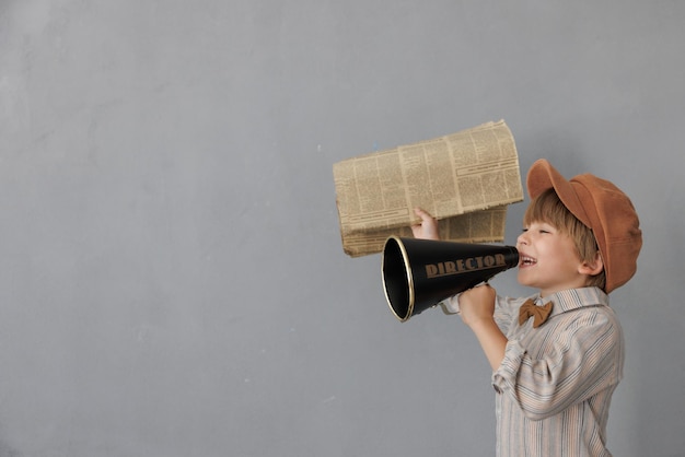 Foto zeitungsjunge schreiend vor grunge-wand-hintergrund junge, der zeitung verkauft