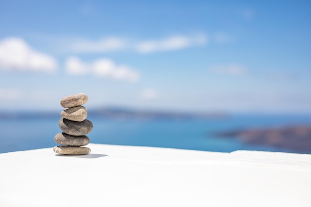 Zen-Steine auf schönem weißem Holzboden gegen blauen Himmel. Verträumte Natur, inspirierende Natur