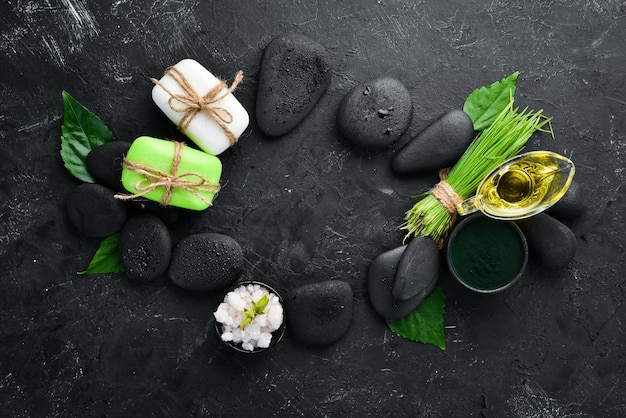 Zen-Steine und Blätter mit Wassertropfen Spa-Hintergrund mit Spa-Zubehör auf dunklem Hintergrund Draufsicht Freier Platz für Ihren Text