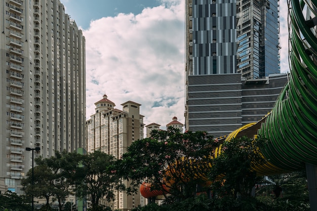 Zentrales Stadtbild von Jakarta mit Hochhaus, Wolkenkratzern und Hotel im touristischen Bereich mit grünen Bäumen.