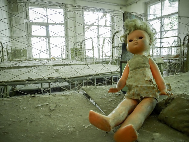 Zerbrochene Puppe sitzen in der verwüsteten und verlassenen Kernzone von Tschernobyl in der Ukraine
