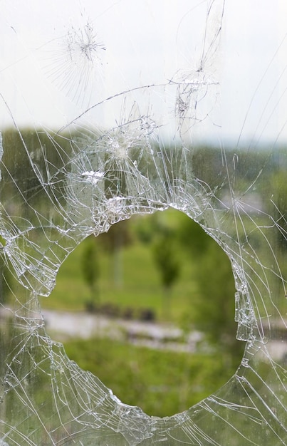 Zerbrochenes Glasfenster, das durch eine Kugel zerbrochen wurde