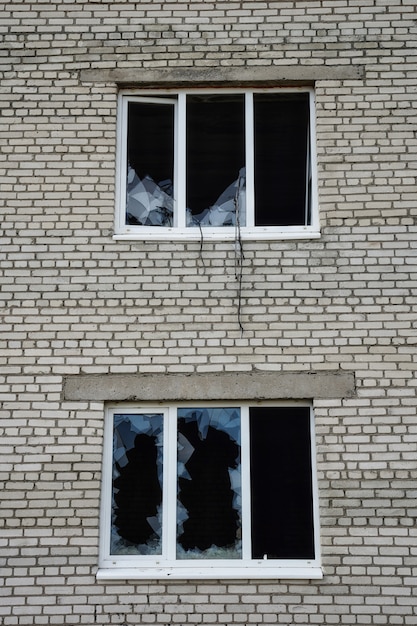 Zerbrochenes Glasfenster draußen Nahaufnahme Foto eines Lochs in einem zerbrochenen Fenster