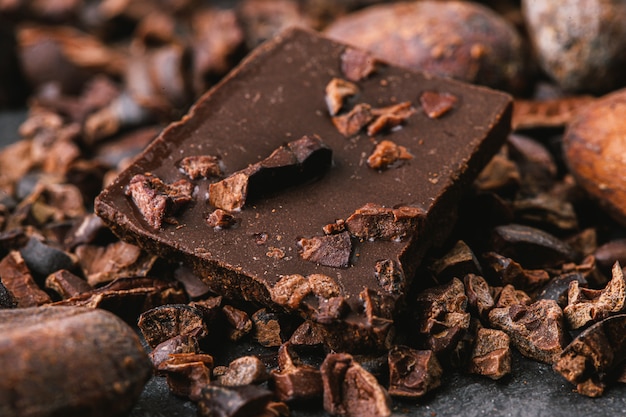 Zerkleinerte dunkle Schokoladenstücke und Kakaobohnen, Draufsicht