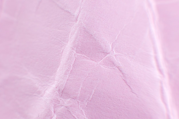 Zerknitterter rosa Papierhintergrund. Echte Makro-zerschlagene Textur. Nahaufnahme Foto.