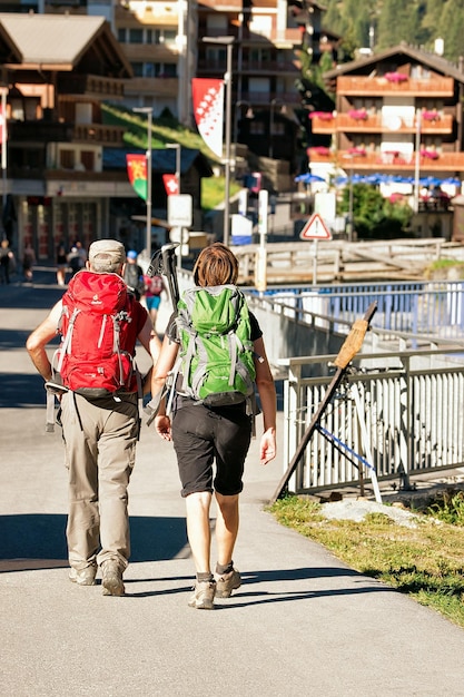 Zermatt, Schweiz - 24. August 2016: Rucksacktouristen auf der Straße der Kurstadt Zermatt in der Schweiz im Sommer.