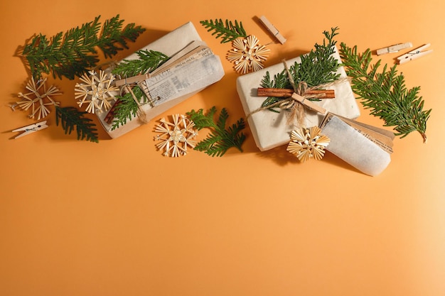 Zero Waste Geschenkkonzept. Umweltfreundliche Verpackung für Weihnachten oder Neujahr. Festliche Schachteln aus Bastelpapier mit verschiedenen organischen Dekorationen. Trendiges hartes Licht, dunkler Schatten, Draufsicht, flache Lage