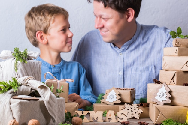 Zero Waste Weihnachtskonzept Vater und Sohn verpacken Geschenke