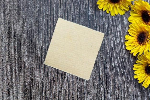 Zerrissenes braunes Papier auf hölzerner Oberfläche und Sonnenblumenflachlage mit Kopierplatz direkt darüber