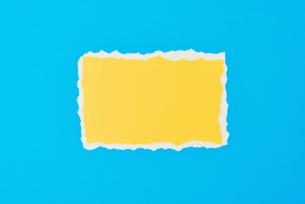 Zerrissenes gelbes Papier zerrissenes Randblatt auf Blau