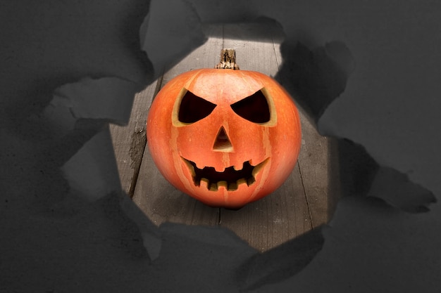 Zerrissenes Papier mit Jack-o-Lantern auf einem Holztisch