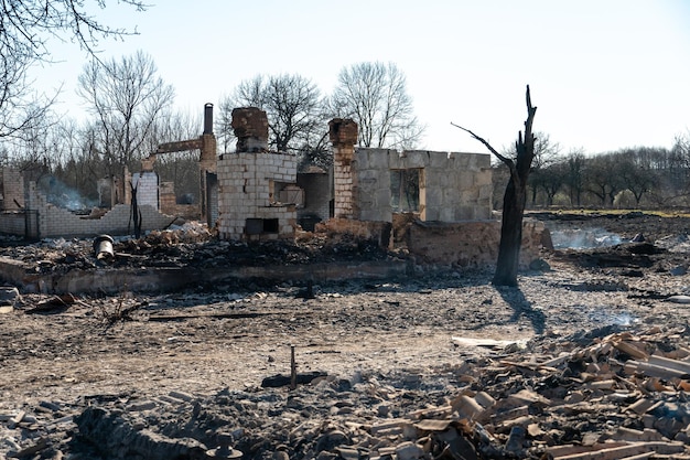 Zerstörte Häuser infolge eines Brandes in Russland Ziegel und Teile von Mauern diverse Haushaltsgegenstände zerbrochene Fenster mit Asche bedeckt liegen auf der Erdoberfläche Naturkatastrophe