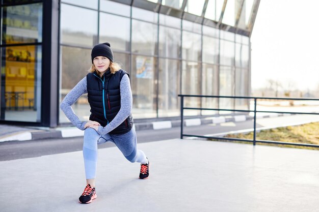 Ziemlich athletische Frau, die allein im Park trainiert Frau beim Aufwärmen in der Natur