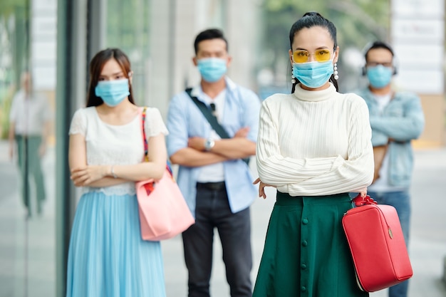 Ziemlich elegante junge Frau in medizinischer Maske, die draußen steht