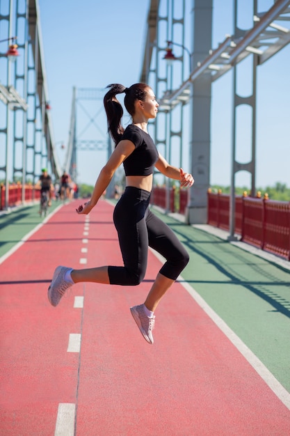 Ziemlich fittes Modell in Sportbekleidung, das während des Trainings springt. Platz für Text