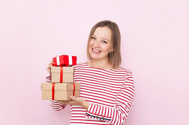 Ziemlich glückliche Frau mit Geschenkboxen.