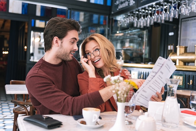 Ziemlich positives Paar, das Essen wählt und sich ansieht