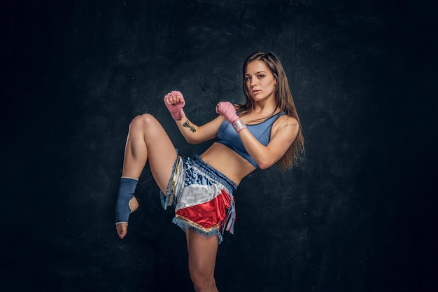 Ziemlich starke Frau demonstriert ihre Kickboxer-Pose, während sie für Fotografen posiert.