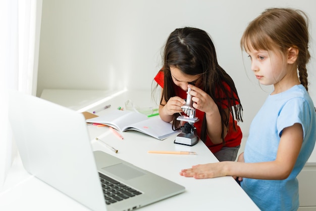 Ziemlich stilvolle Schulmädchen, die während ihres Online-Unterrichts zu Hause lernen, soziale Distanz während der Quarantäne, Selbstisolation, Online-Bildungskonzept