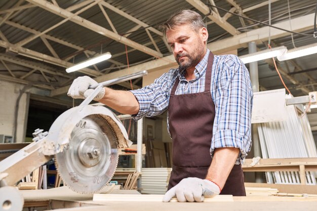 Zimmermann, der Holz in der Tischlerei schneidet