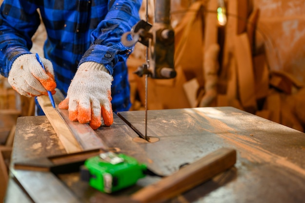 Zimmermann oder Handwerker Verwenden Sie eine Kreissäge, um das Holz zu sägen. In der Werkstatt Zimmerei-Bürohintergrund.