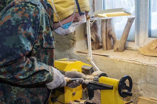 Zimmermann schärft das Holz auf einer Drehbank