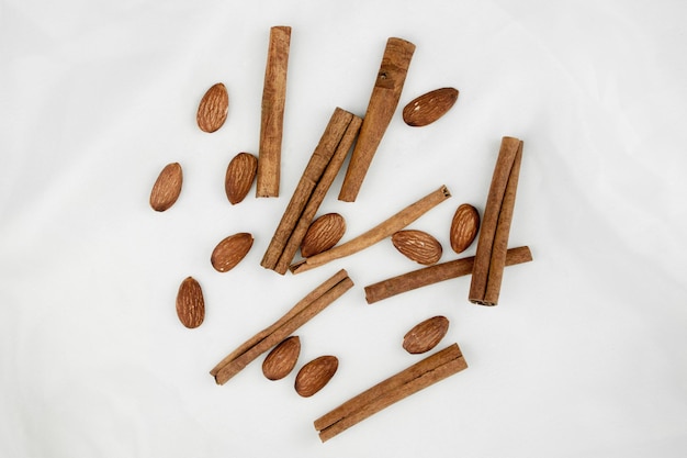 Zimt und Mandeln Gewürze Nüsse Draufsicht auf weißem Hintergrund Cashewnüsse Erdnüsse Cassia