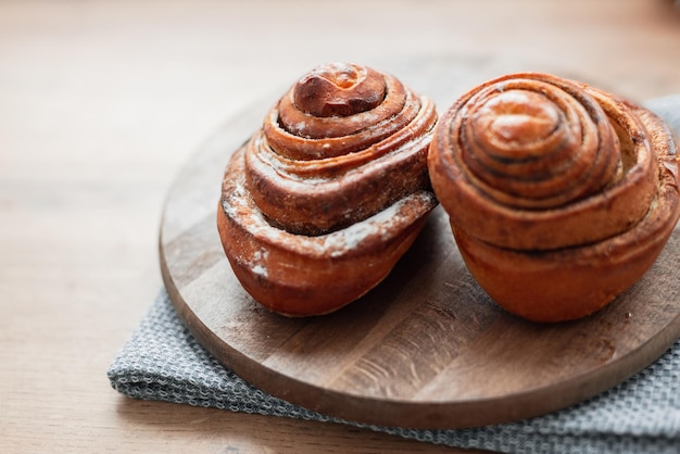 Zimtbrötchen auf einem Holzbrett in der Küche Köstliche süße Backwaren