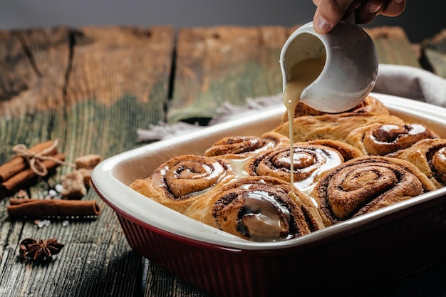 Zimtbrötchen Zimt mit Zimt und weißer Sahnesauce süße traditionelle Dessertbrötchen