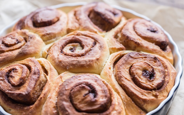 Zimtschnecken auf dem hölzernen Hintergrund