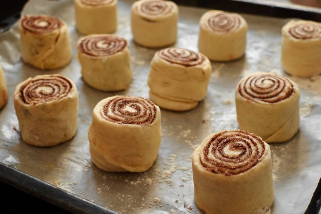 Zimtschnecken - Cinnabon Kochprozess roher Teig. Lebensmittelhintergrund