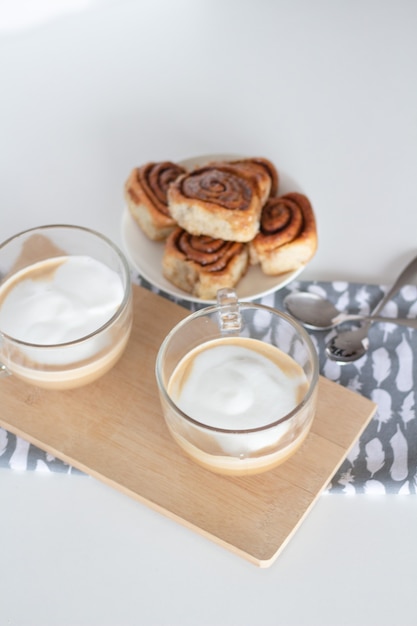 Zimtschnecken und Tasse Kaffee auf weißem Hintergrund