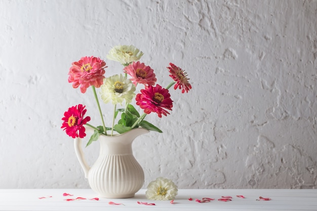 Zinnia flores sobre superficie blanca