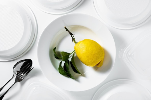 Zitrone auf einem Teller Gedeck Geschirr Besteck auf weiß