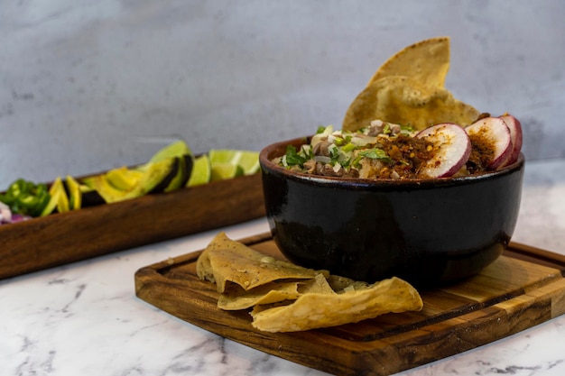 Zitrone und Avocado auf einer Holzplatte, um traditionelle mexikanische Fleischgerichte anzuziehen